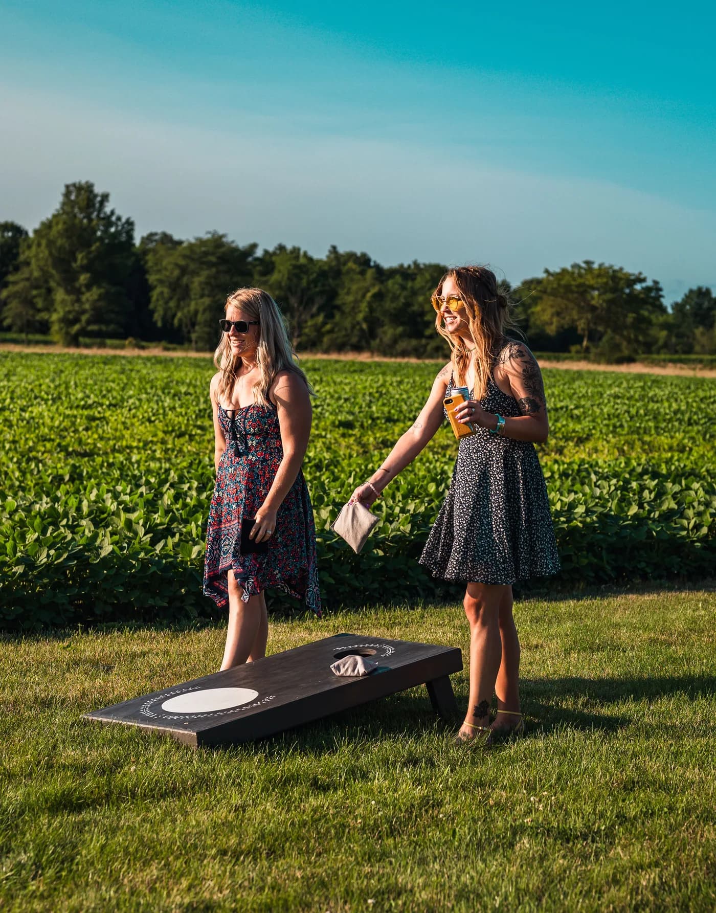 Two players enjoying a casual outdoor cornhole game